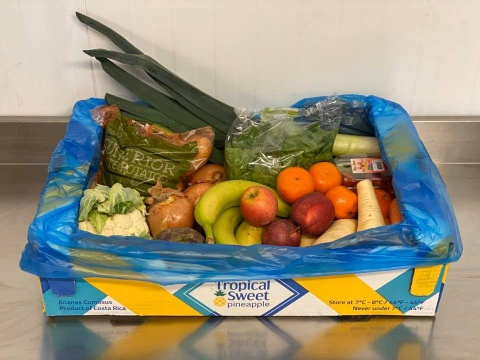 A basket of fruit vegetables and potatoes.