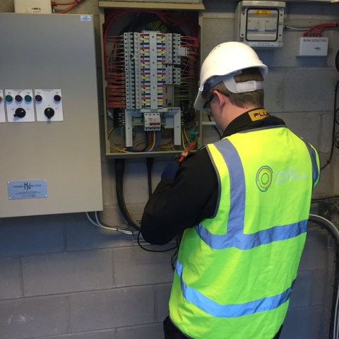 Image of a worker from O grady electrical next to an electrical switchboard on location.